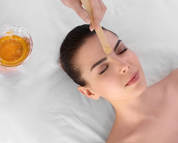 Femme recevant une épilation au sucre sur le front, bol de sucre à proximité à La Chapelle-Vendômoise près de Blois dans le Loir-et-Cher 41