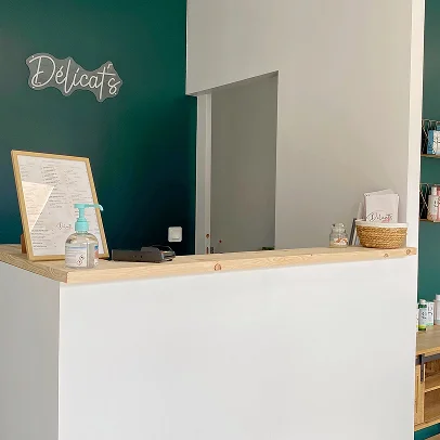 Un comptoir de réception avec un désinfectant, un menu et un signe Délicats.