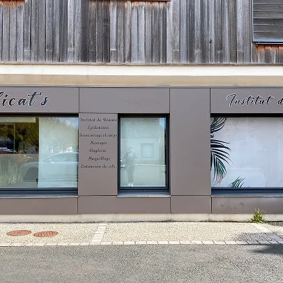 Façade de salon de beauté avec vitrines et menu de services.