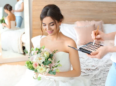 Future mariée souriante tenant un bouquet de fleurs pendant l'application du maquillage à La Chapelle-Vendômoise près de Blois dans le Loir-et-Cher 41